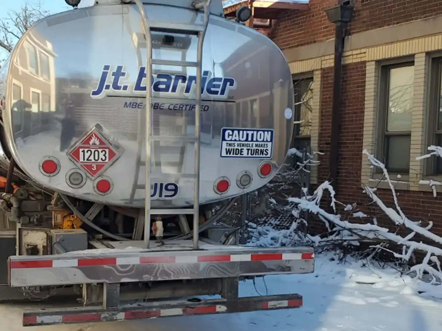 A truck is parked in the snow next to a building.