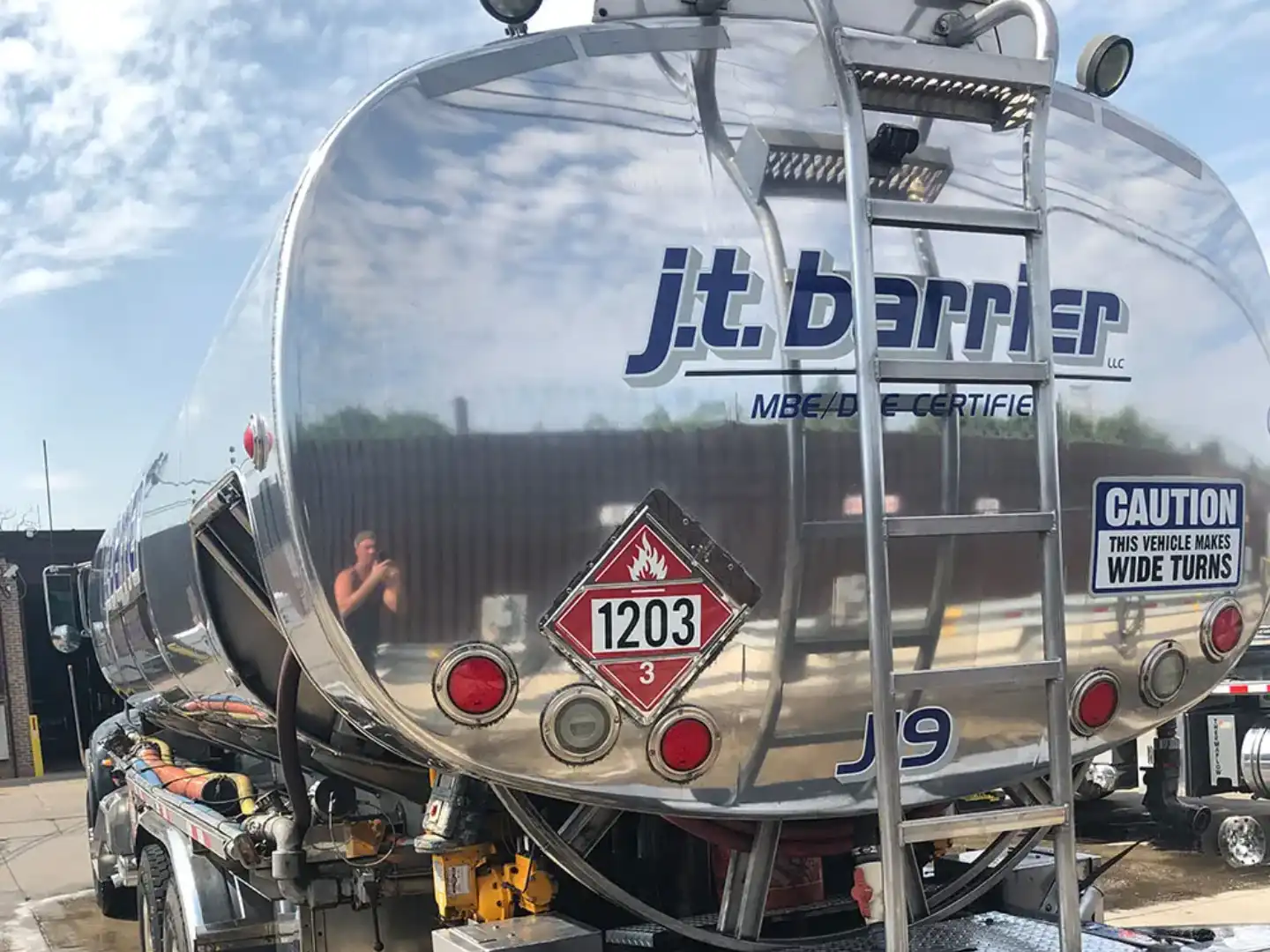 A silver tanker truck parked in a parking lot.