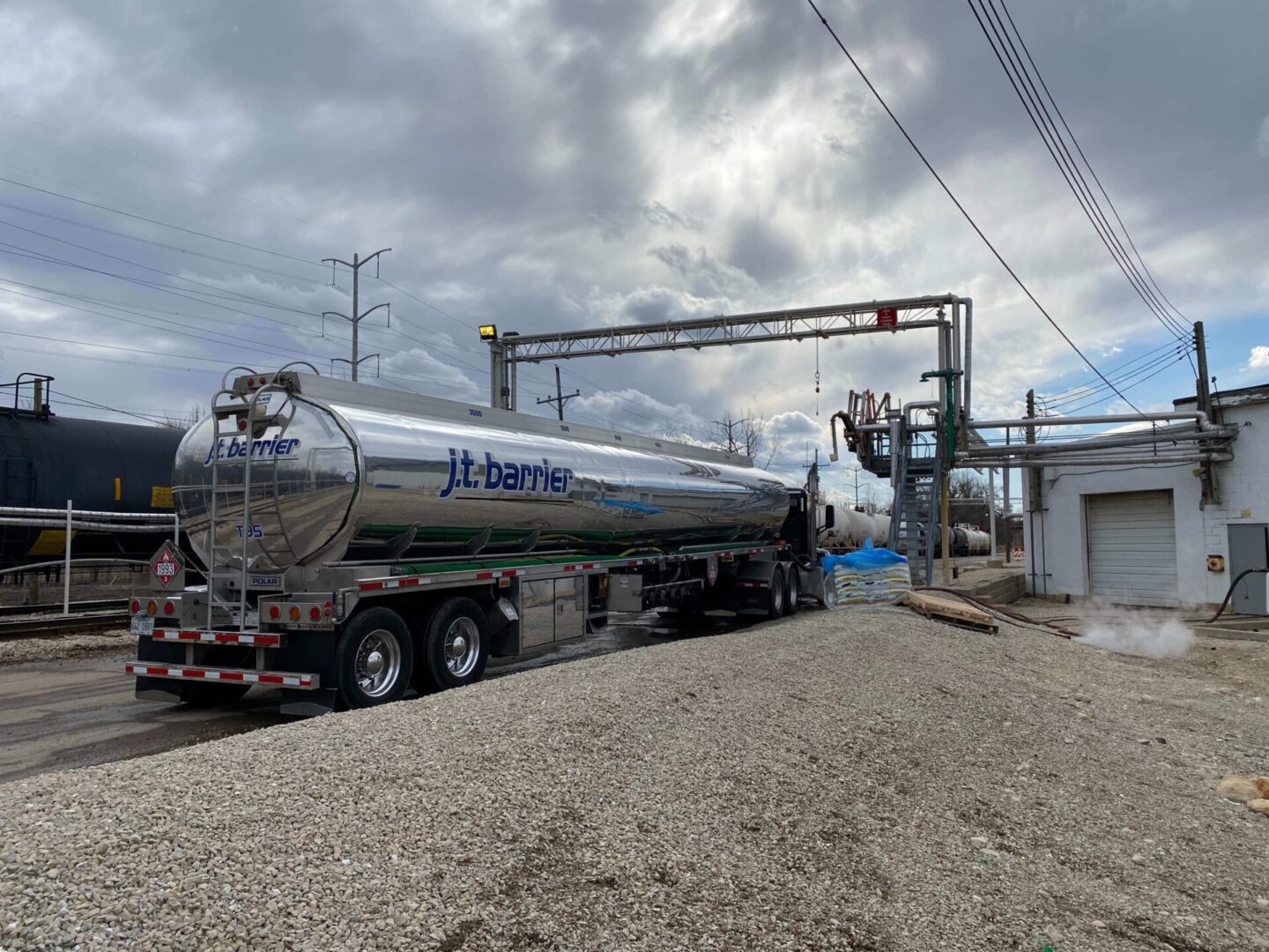 A large tank truck is parked in front of a building.