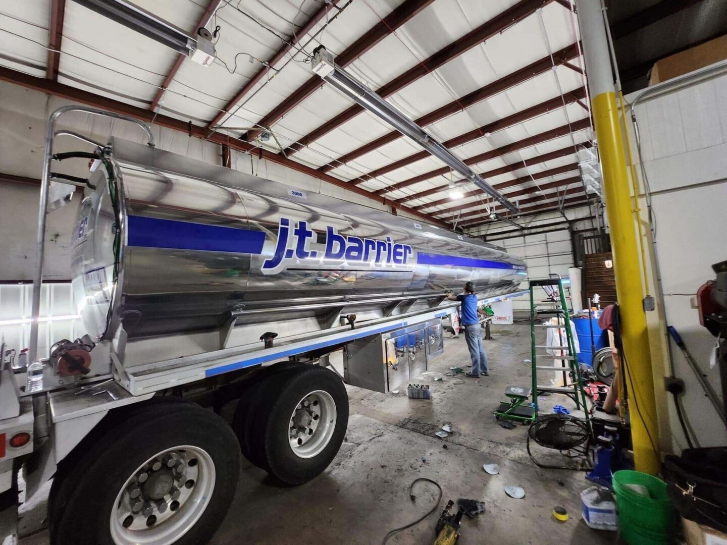 A man is working on a truck in a garage.