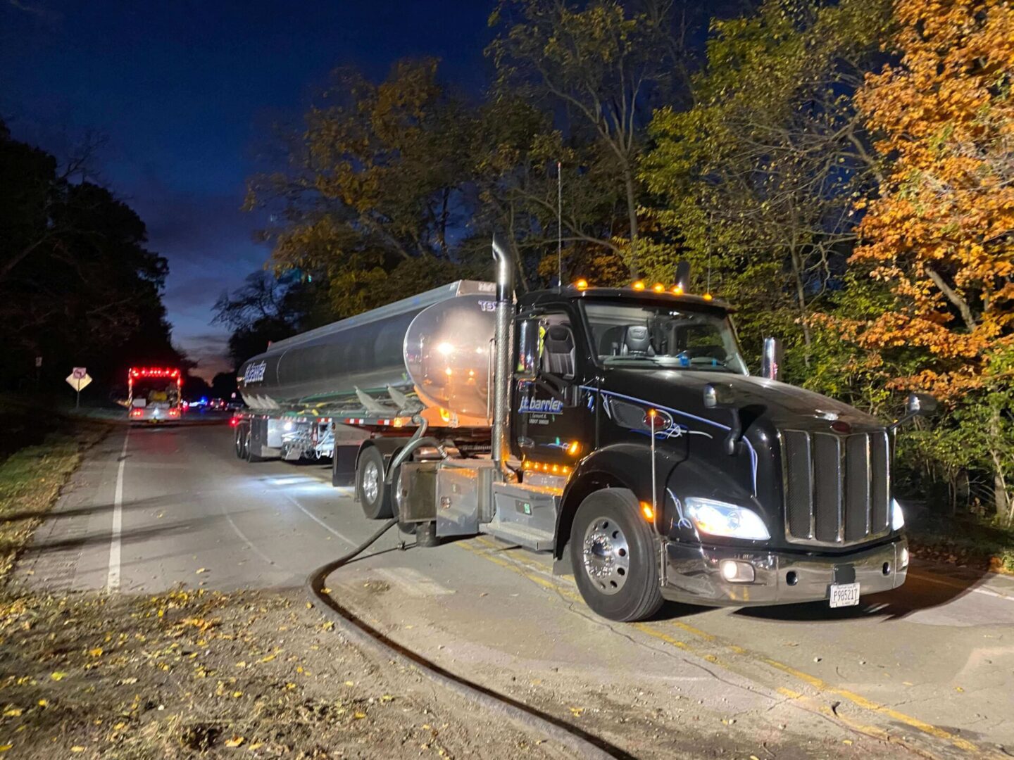 A large truck is parked on the side of a road at night.