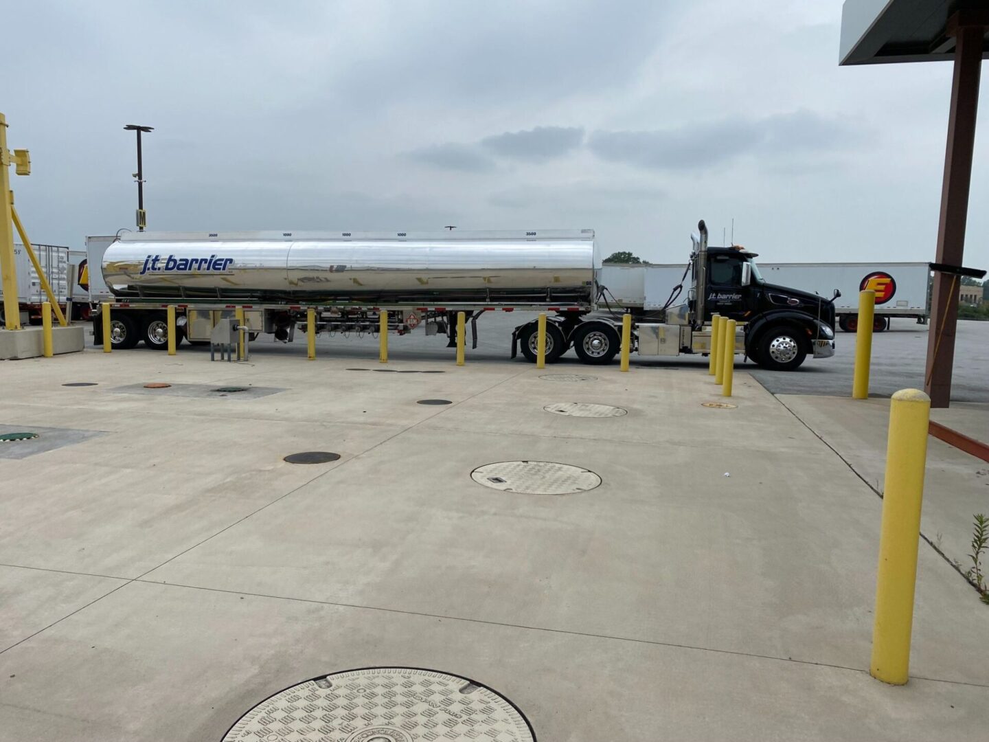 A large truck is parked in front of a gas station.