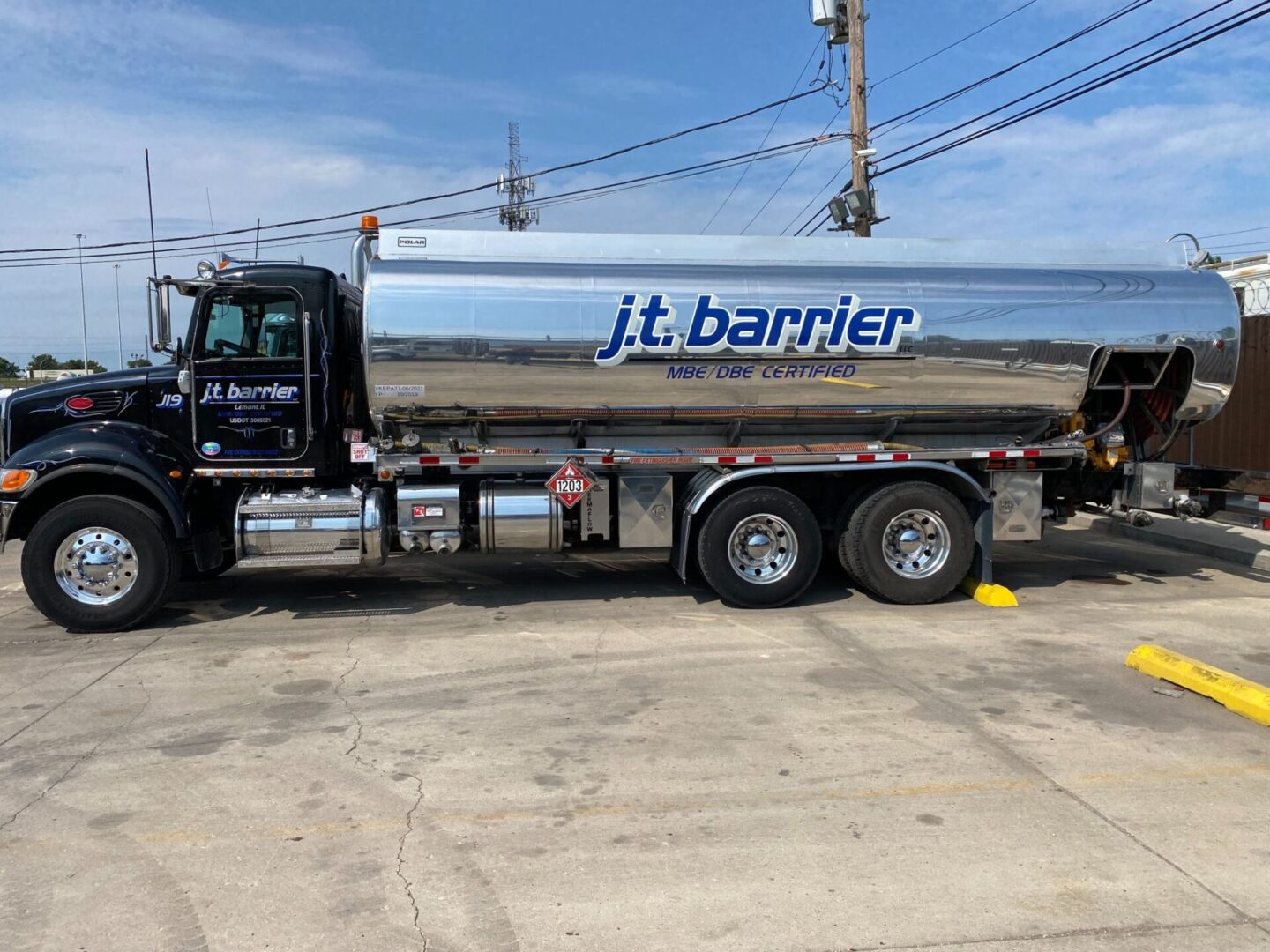 A silver tanker truck parked in a parking lot.