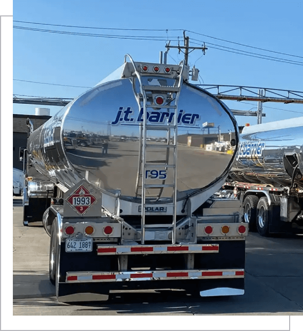 A silver tanker truck parked in a parking lot.