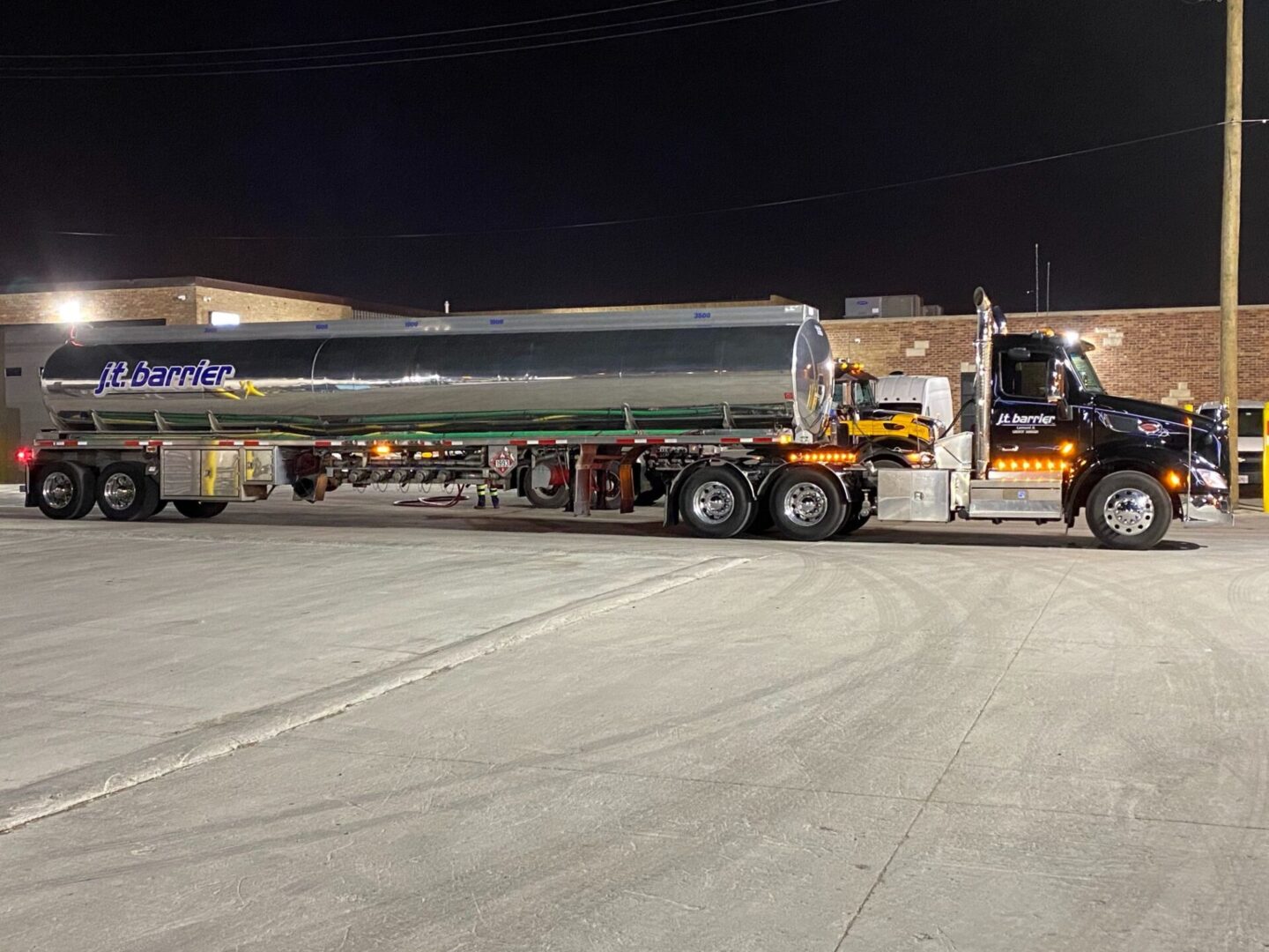 A large tanker truck parked in a parking lot at night.