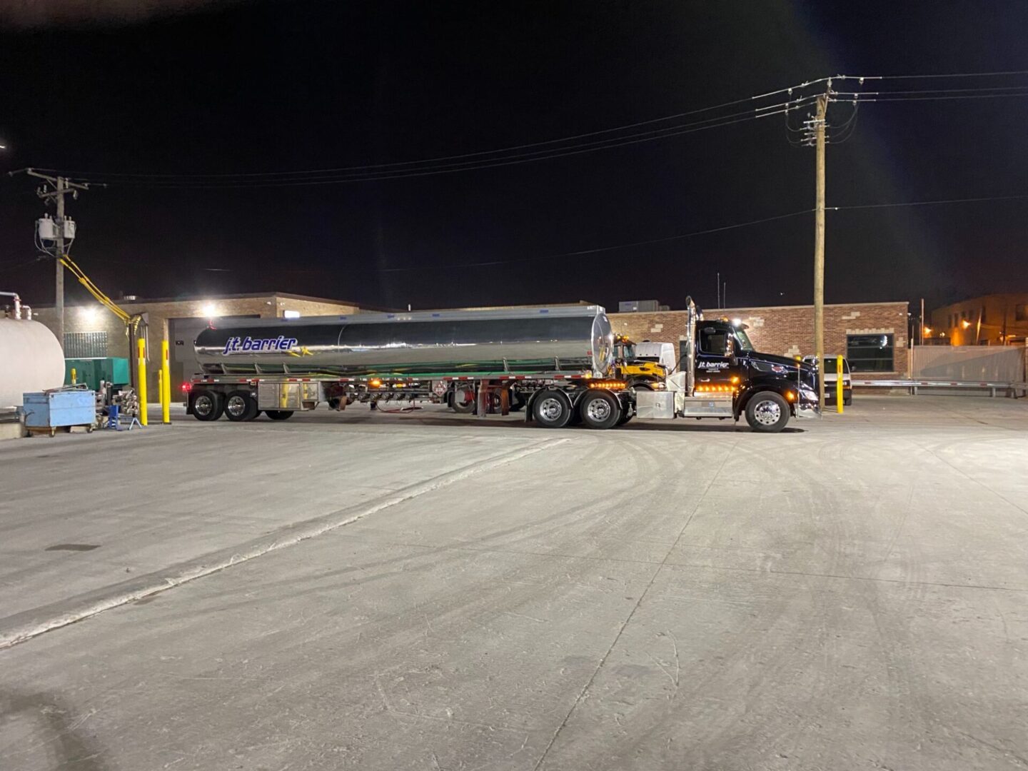 A large truck parked in a parking lot at night.